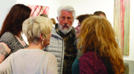 Ed Moses at his art opening at William Turner gallery, surrounded by admirers. Photo by Lynda Burdick.